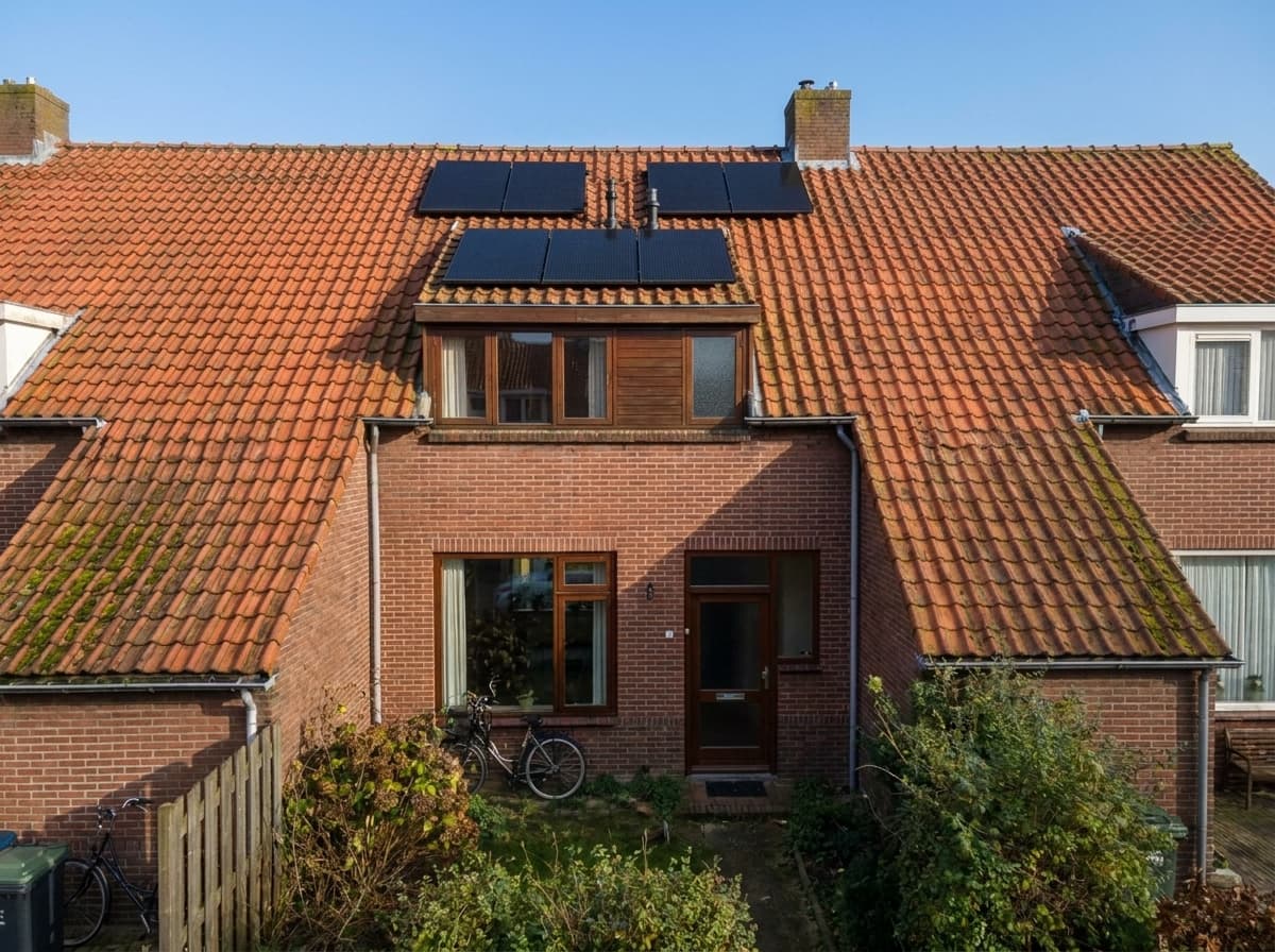 Zelfde rijwoning met 6 zonnepanelen onder een heldere blauwe Nederlandse lucht